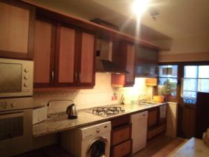 a kitchen with wooden cabinets and a stove top oven at Casa Riqueta Silva in Bordeira