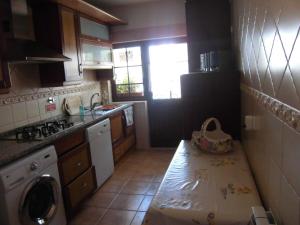a kitchen with a sink and a washing machine at Casa Riqueta Silva in Bordeira +10 photos