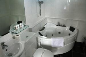 a white bath tub sitting next to a white toilet at The Imperial Hotel in Fort William