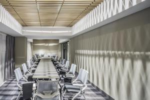 a long conference room with a long table and chairs at Almaty Hotel in Almaty