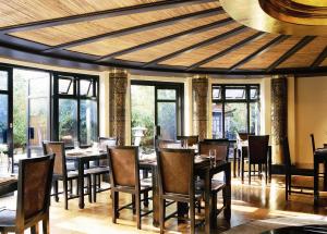 a dining room with tables and chairs and windows at Careys Manor Hotel & SenSpa in Brockenhurst