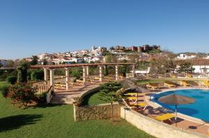 a resort with a swimming pool with chairs and a bridge at Hotel Colina Dos Mouros in Silves