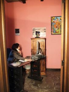 une femme assise sur un bureau avec clavier dans l'établissement Apartamentos La Iguana, à Hervás