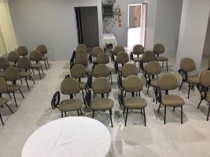 un grupo de sillas y mesas en una habitación en Hotel Apolo XVI, en Criciúma