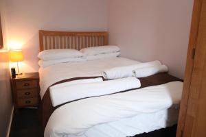 2 letti in una camera con lenzuola e cuscini bianchi di Castleyards Apartment 1 a Kirkwall