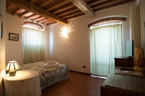 a bedroom with a bed and a tv and windows at Arpaderba B&B in Livorno
