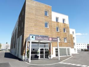 un bâtiment avec un panneau devant lui dans l'établissement Les Clefs du Roy by Popinns, à Buc