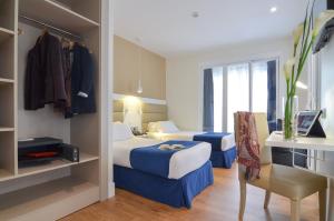 a hotel room with two beds and a desk at Hotel Miau in Madrid