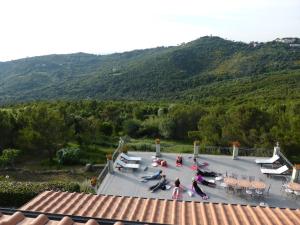 a group of people sitting on a patio with mountains in the background at Arpaderba B&B in Livorno