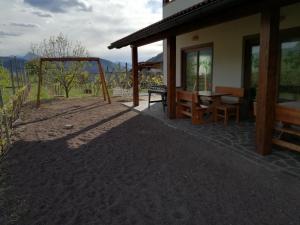 eine Terrasse eines Hauses mit einem Tisch und Stühlen in der Unterkunft Agriturismo Le Cavade in Cembra