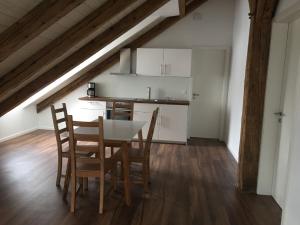 una cucina e una sala da pranzo con tavolo e sedie di Ferienwohnung am Herzogspark a Ratisbona