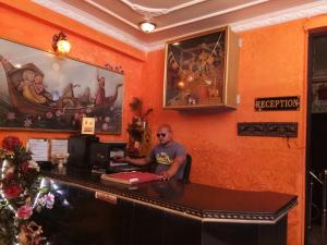a man sitting at a desk in a bar at Haveli Taragarh Palace in Būndi