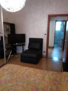 salon z krzesłem i telewizorem w obiekcie Lecce w Turynie