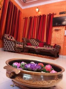 un bol lleno de flores en una habitación con sofá en Haveli Taragarh Palace, en Bundi