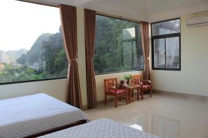 a bedroom with two beds and a table and chairs at Sierra Homestay in Ninh Binh