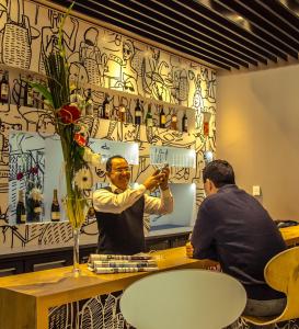 two men sitting at a table drinking from a glass at Ibis Rabat Agdal in Rabat