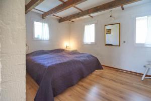 1 dormitorio con 1 cama en una habitación con ventanas en Møllegade 1 Holiday House, en Nordborg
