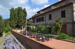 un patio con mesas y sillas frente a un edificio en Agriturismo Le Case di San Vivaldo, en Montaione