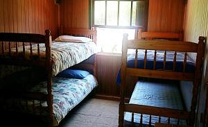 a bedroom with two bunk beds and a window at Pousada Alvorada in Cambará