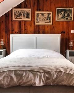 - un lit blanc dans une chambre dotée de murs en bois dans l'établissement Duplex Lisbon Castle Sao Jorge, à Lisbonne
