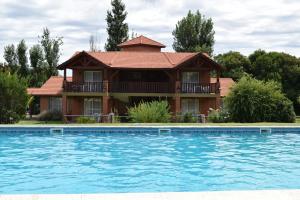 a house with a pool in front of it at Posada Los Alamos in Merlo