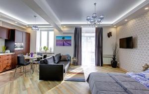 ウファにあるAzbuka Apartment on Babushkina 52のベッドルーム1室、リビングルーム(ベッド1台付)、キッチンが備わります。