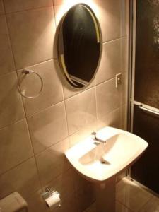 a bathroom with a sink and a mirror on the wall at Pousada Félix in Nova Petrópolis