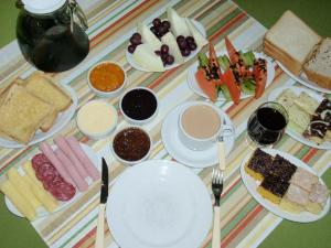 a table with plates of food on a striped table cloth at Pousada Félix in Nova Petrópolis