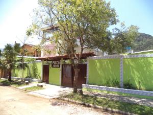a green building with a sign that reads proxy at Pisco Chalés in Ubatuba