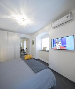 ラ・スペツィアにあるIl Mare in Piazzaのベッドルーム1室(ベッド1台、壁にテレビ付)