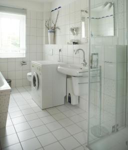 a white bathroom with a sink and a washing machine at Ferienhaus Marleen in Pritzier