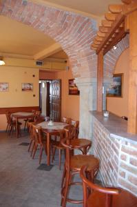 a restaurant with wooden tables and chairs and a brick wall at Apartman Majak Sec in Seč