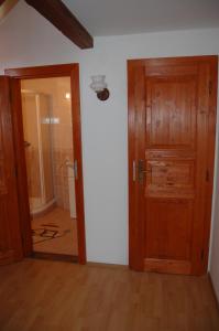 a room with a wooden door and a bathroom at Apartman Majak Sec in Seč