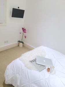 laptopa siedzącego na łóżku w obiekcie The Studio - Heart Of Primrose Hill w Londynie