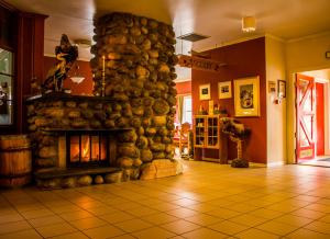 a large stone fireplace in a room with a tile floor at Tysfjord Hotel in Storjord I Tysfjord