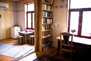 a room with a table and a book shelf with books at Salme Apartment in Tartu
