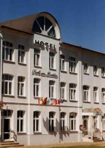 a white hotel with a sign on the side of it at Hotel Perle am Bodden in Ribnitz-Damgarten