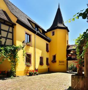 un bâtiment jaune avec un toit noir dans l'établissement L'Abbaye d'Alspach, à Kientzheim