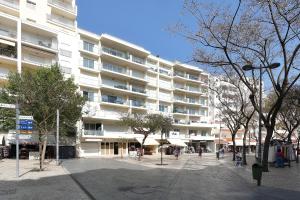 ein großes weißes Gebäude mit Leuten, die davor laufen in der Unterkunft Original 3 Bedroom Downtown in Albufeira