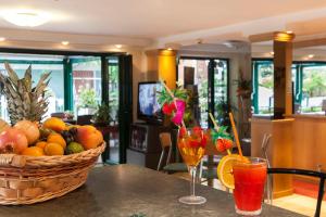 Hotel Verdemare في ريميني: سلة من الفواكه تجلس على طاولة مع مشروبين