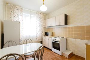 una cucina con tavolo e piano cottura forno superiore di Standard Brusnika Apartment on Maklaya 22 a Mosca