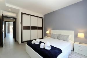 a bedroom with a white bed with two white pillows at Original 3 Bedroom Downtown in Albufeira