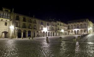 une rue urbaine vide la nuit avec des bâtiments dans l'établissement Hospederia Porta Coeli, à Sigüenza