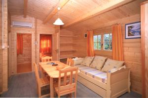 a room with a couch and a table in a cabin at Camping Les Oliviers in Porto Ota