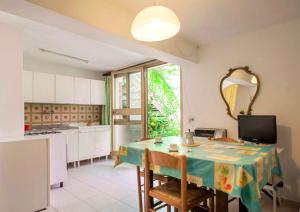 een keuken met een tafel met stoelen en een spiegel bij Casa Furrer in Tirrenia
