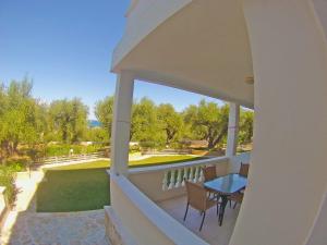 a balcony with a table and chairs and a pool at Pouliezos Koklanis Zante Apartments in Alykes