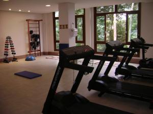 a gym with several tread machines in a room with windows at Flat Particular Pedra Azul in Pedra Azul