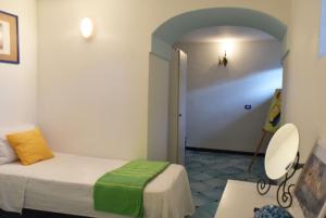 ミノーリにあるVillamena Apartmentのベッドと椅子付きの小さな部屋です。