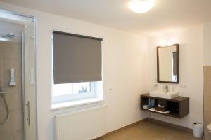 a bathroom with a window and a sink and a mirror at Bierhotel Ranklleiten Almtal in Pettenbach +39 photos