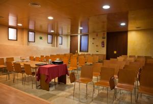 una sala de conferencias con mesas y sillas. en Hospederia Porta Coeli, en Sigüenza
